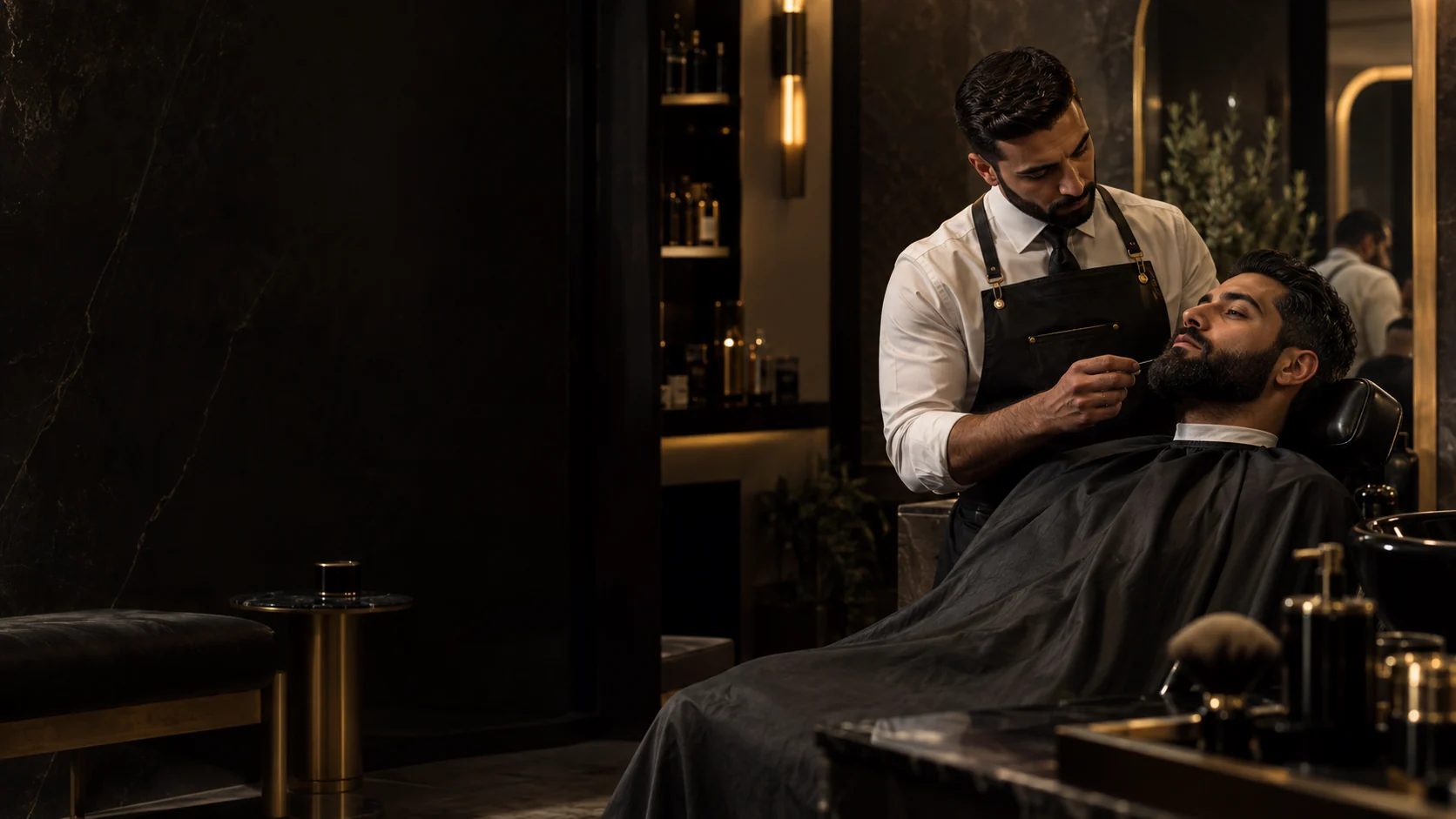 Barber carefully shaping a client's beard in a dark luxury studio